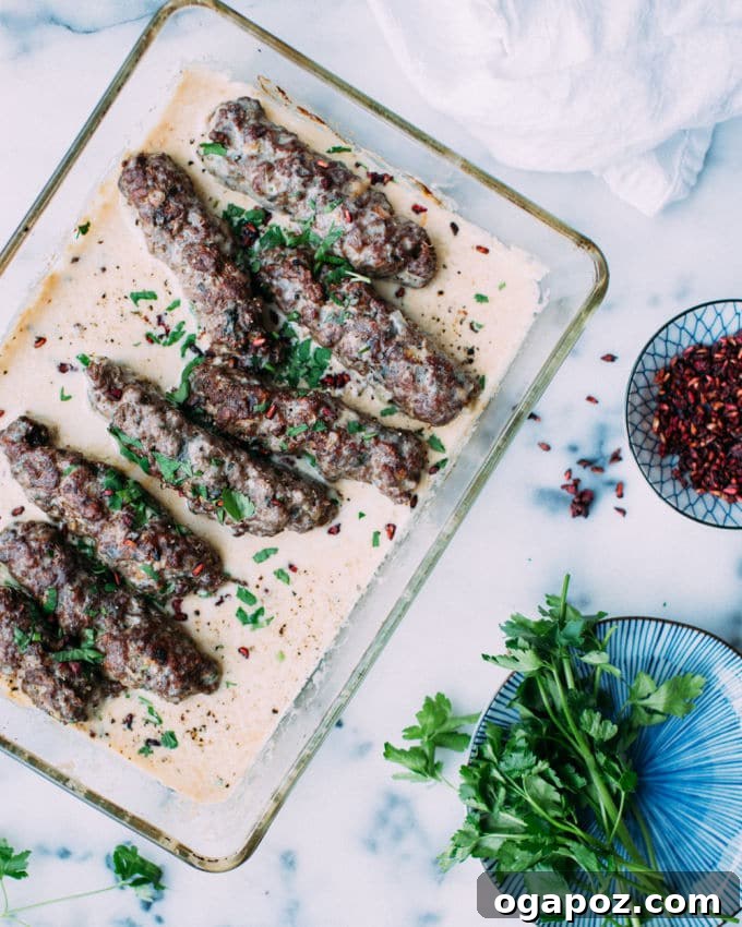 Creamy Tahini Lamb Kofta 4 A close-up of baked Lamb Kofta in Tahini Sauce, garnished with parsley and pomegranate, ready to be served.