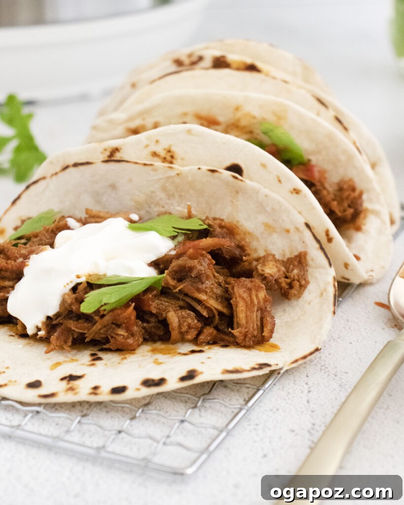 Tender and Crispy Instant Pot Carnitas 2 Instant Pot Carnitas served in warm tortillas as tacos, garnished with cilantro and lime.