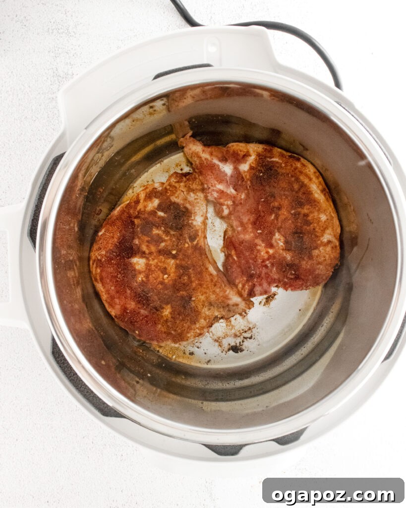 Tender and Crispy Instant Pot Carnitas 6 Seared pork chops simmering in liquid inside the Instant Pot.