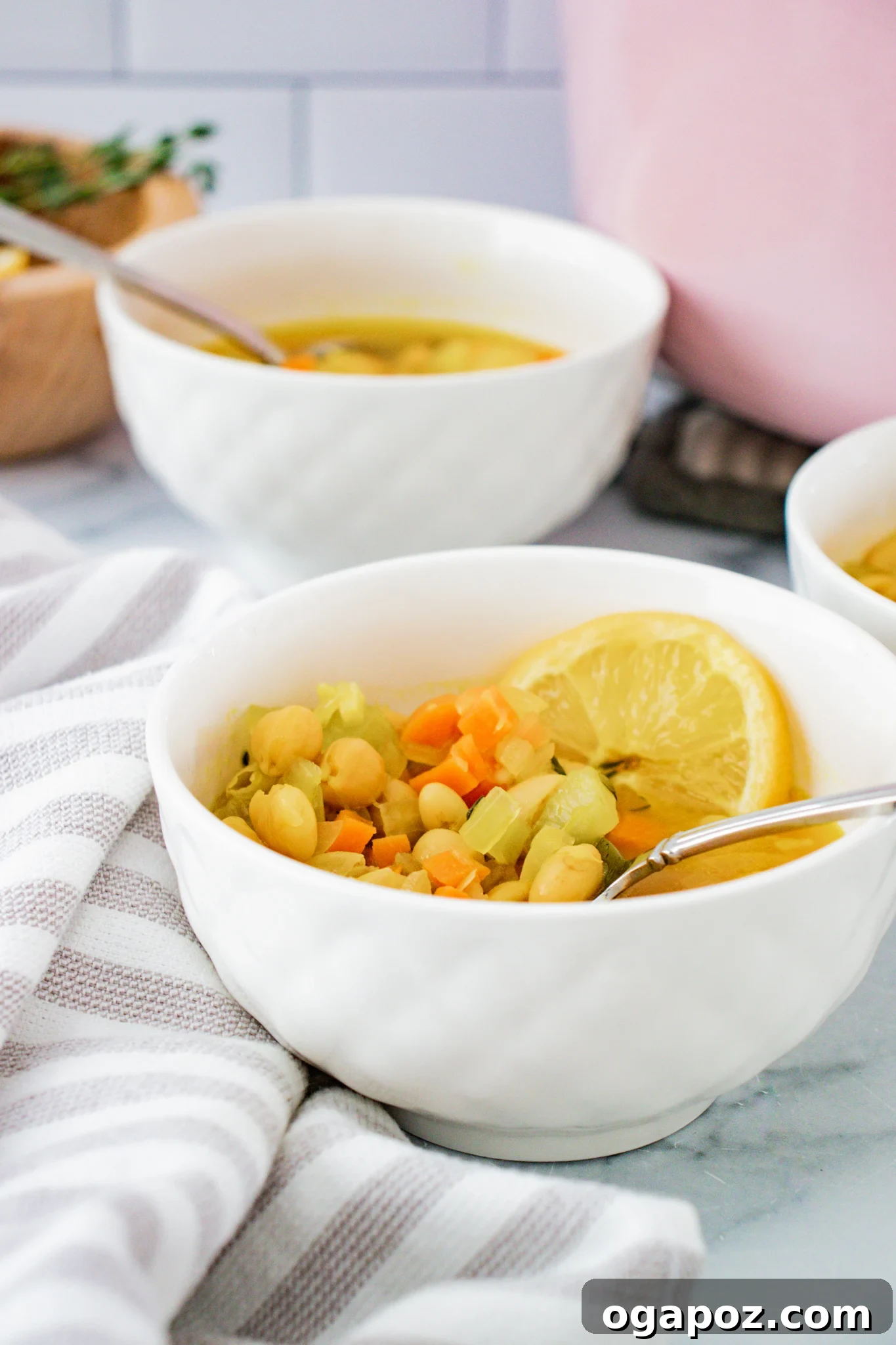 Effortless Vegetable Bean Soup 4 A serving of Easy Vegetable Bean Soup garnished with fresh herbs, with spoons resting on the bowl's edge.