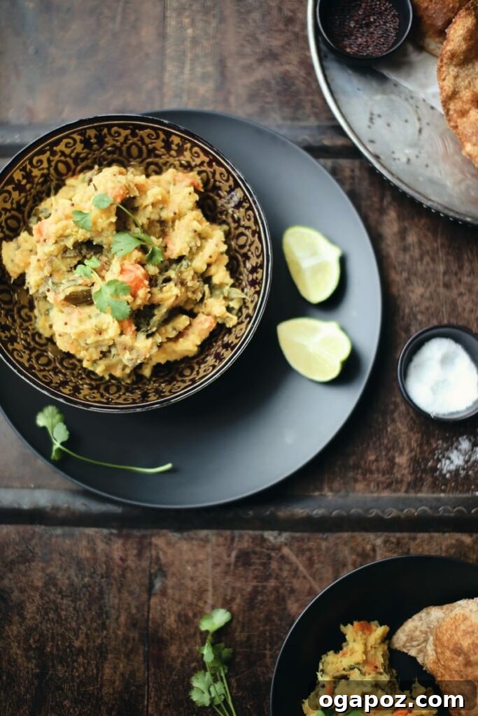 Flavorful Indian Vegetarian Dinner Ideas 12 Delicious Poori Bhaji, featuring a stack of puffy fried flatbreads served with a spiced potato masala, garnished with fresh lime wedges.