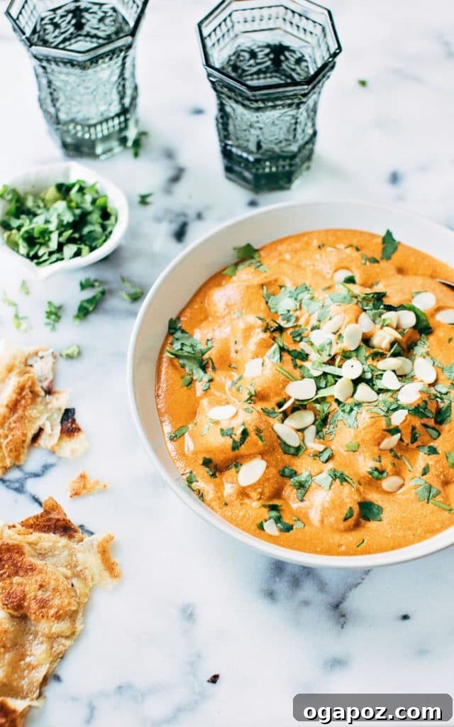 Flavorful Indian Vegetarian Dinner Ideas 4 Decadent homemade Paneer Butter Masala in a charming bowl, generously topped with fresh cilantro and slivered almonds, ready to serve.