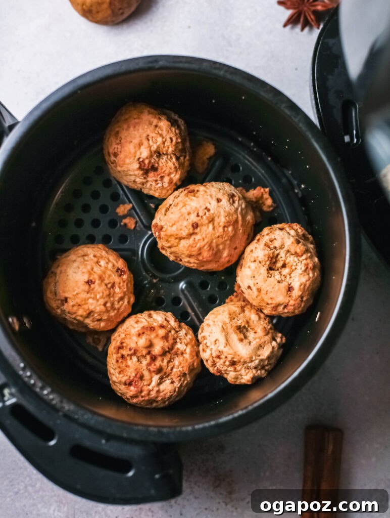 Easy Air Fryer Donut Bites 8 The air fryer basket is filled with pumpkin donut holes, which are turning golden brown and perfectly cooked through, midway through the air frying process.