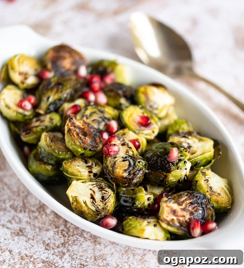 Balsamic Glazed Brussels Sprouts 2 Roasted Balsamic Brussels Sprouts in a white serving dish, garnished with pomegranate arils.