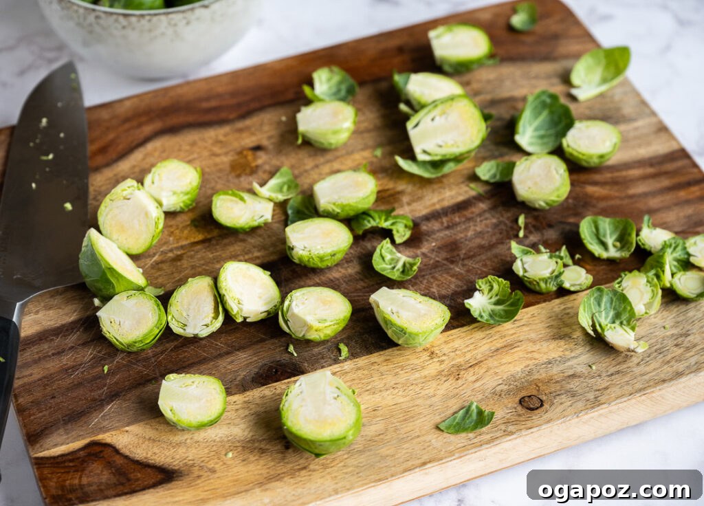 Balsamic Glazed Brussels Sprouts 4 Fresh Brussels sprouts, trimmed and sliced in half, on a wooden cutting board, ready for roasting.