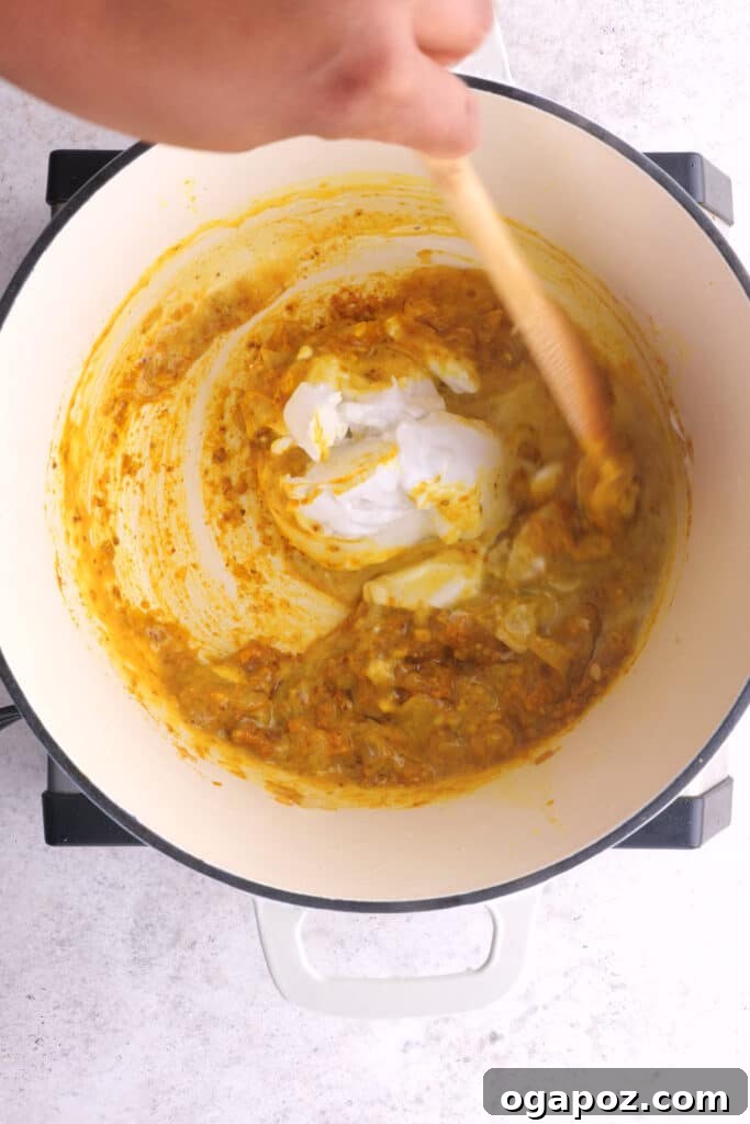 Fiery Goan Pork Vindaloo 6 Pouring creamy coconut milk into the Vindaloo curry pot, adding richness and mellowing the spice.