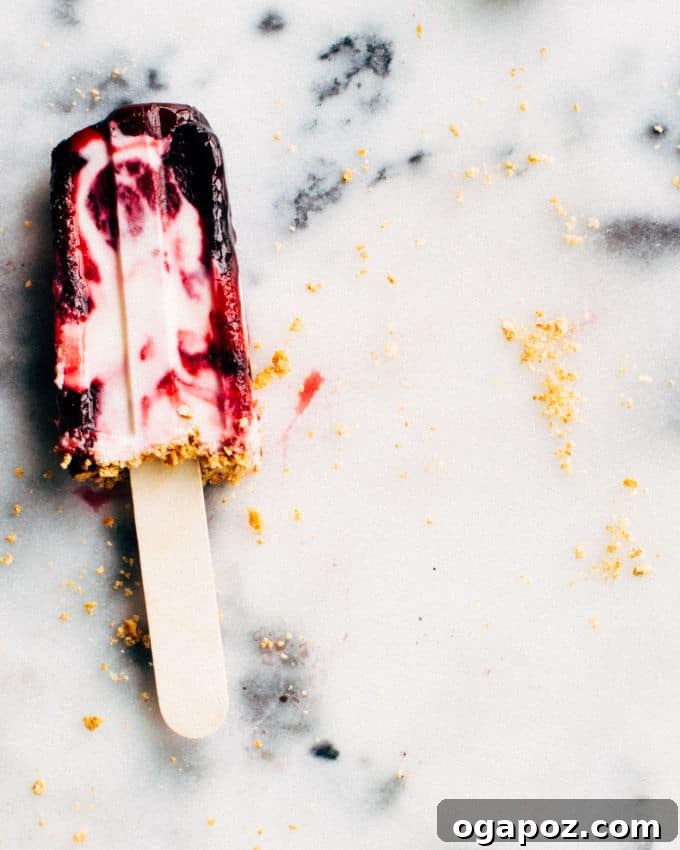 Stacked Cherry Cheesecake Popsicles displaying their layered appearance and refreshing quality.