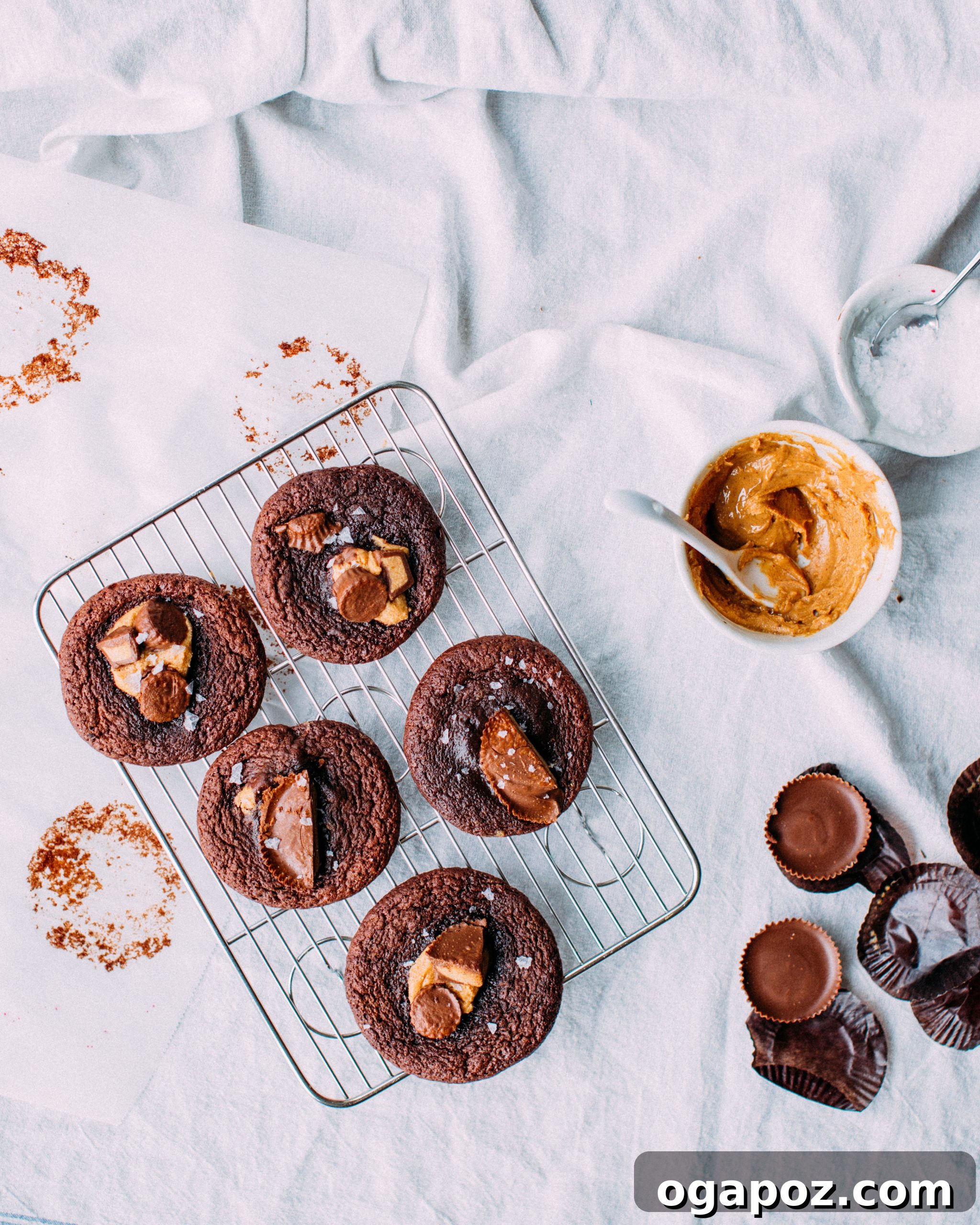 Reeses Peanut Butter Cup Delights 5 Stuffed or topped peanut butter cup cookies on a baking tray before baking, with flaky salt.