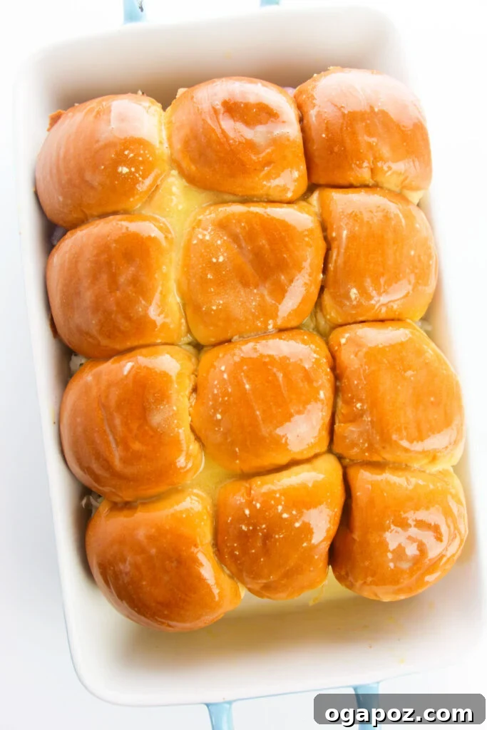 Effortless Chicken Sliders 11 The top half of the slider buns placed over the chicken, cheese, and onion layers in a baking dish.