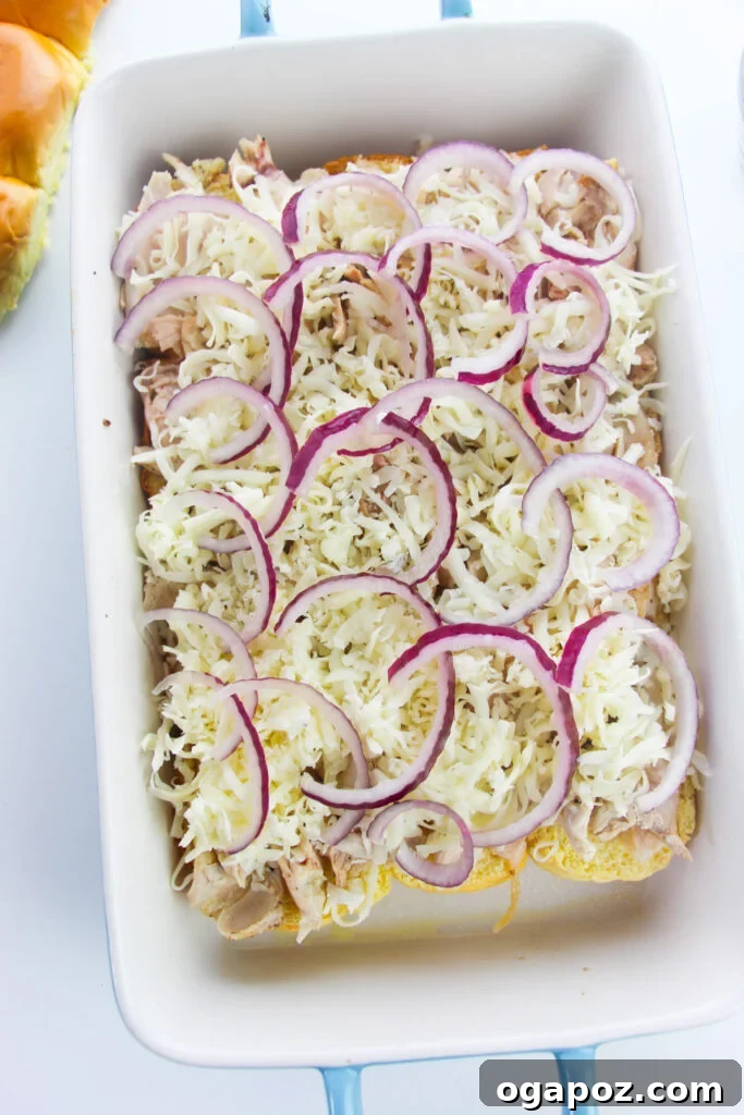 Effortless Chicken Sliders 10 Thinly sliced red onions arranged on top of the cheese layer for Easy Chicken Sliders.
