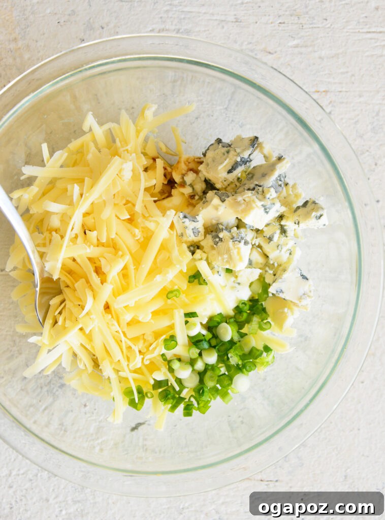 Your Guide to an Irresistible Cheese Ball 6 All cheese ball ingredients mixed together in a medium bowl, showing the creamy texture and distribution of green onions.