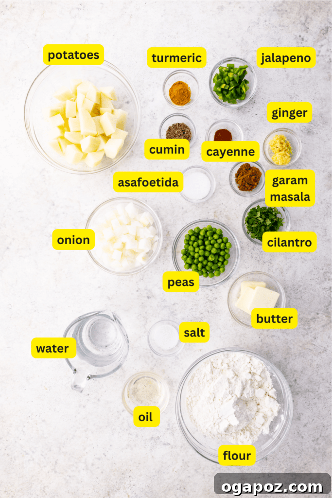 Elevate Your Samosas Irresistible Filling Secrets 3 A curated display of fresh, whole ingredients laid out on a clean kitchen counter, including russet potatoes, a yellow onion, fresh ginger root, green jalapeños, a bowl of bright green peas, and various spice jars, ready for making potato samosas.