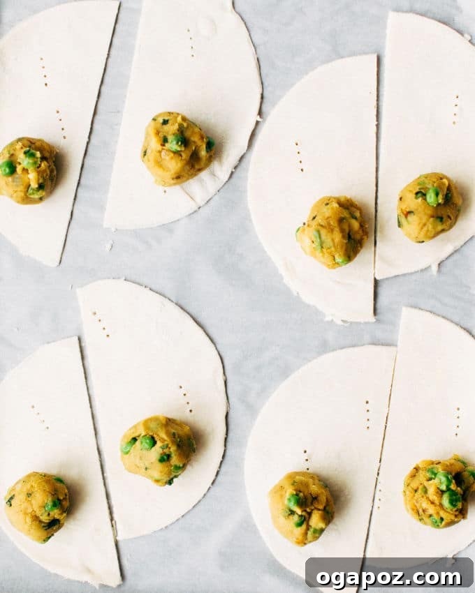 Elevate Your Samosas Irresistible Filling Secrets 6 An overhead shot of a vibrant bowl of homemade samosa filling, rich with potatoes, peas, and spices, next to a stack of crispy, golden-brown samosas, suggesting readiness for assembly and enjoyment.