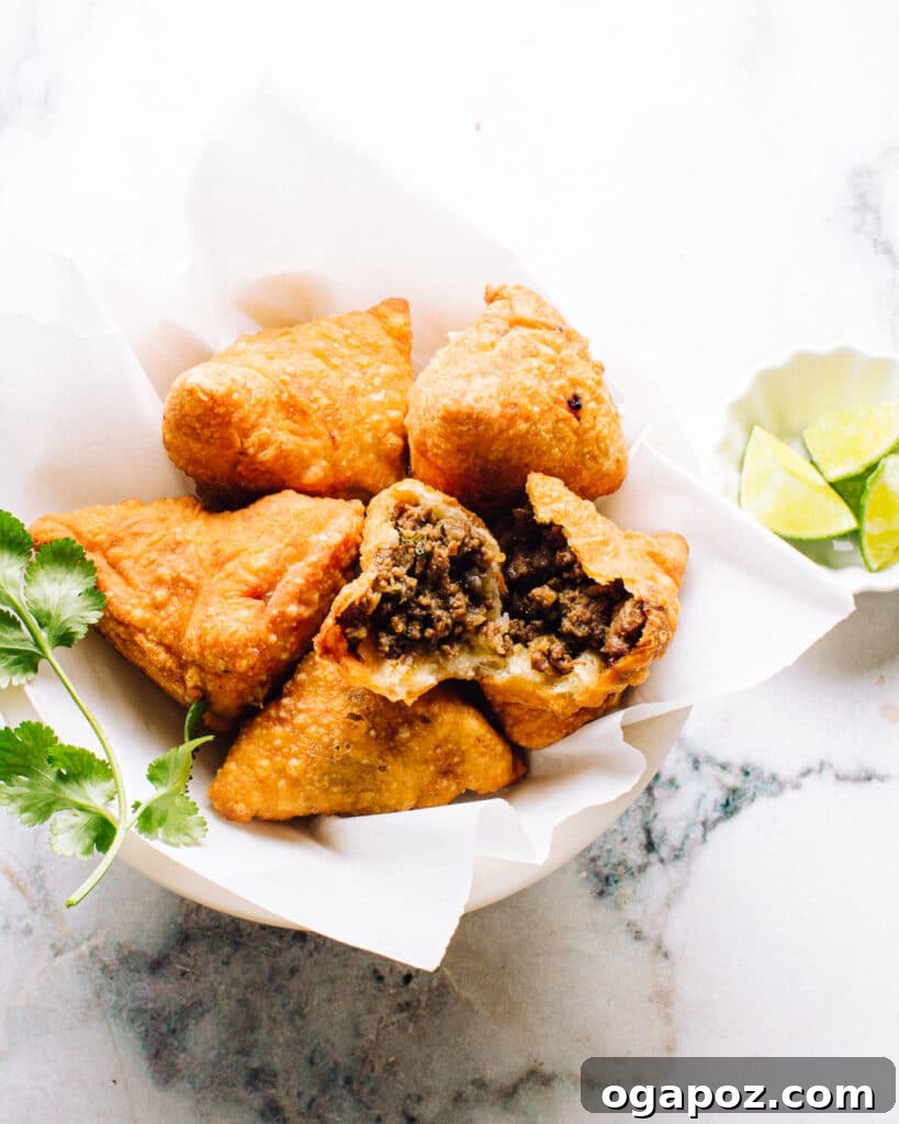 Elevate Your Samosas Irresistible Filling Secrets 7 A crisp, golden-brown samosa with a rich ground beef filling, served alongside a vibrant green chutney, highlighting the versatility of samosa fillings and the perfect pairing with a dipping sauce.