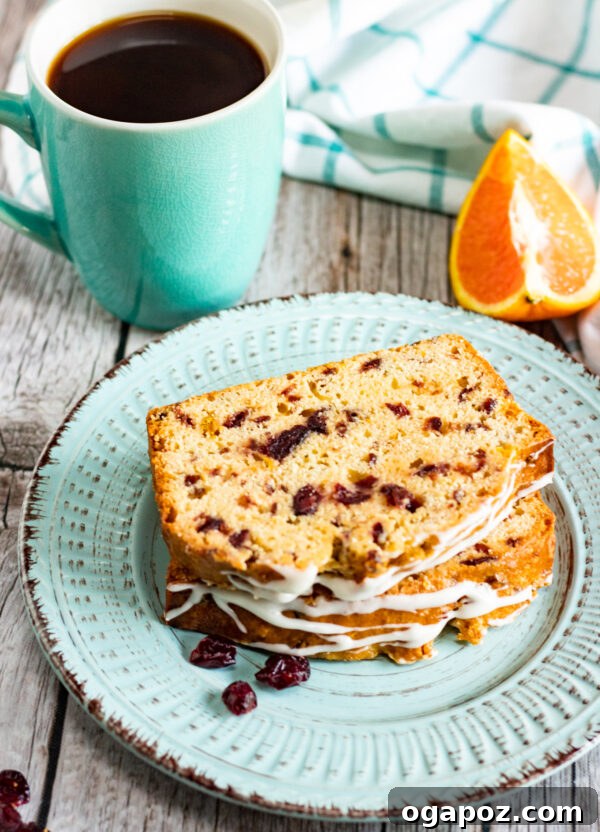 Sweet and Tart Cranberry Loaf 4 A perfectly baked slice of Cranberry Orange Bread with a drizzle of icing on a white plate, ready to be enjoyed.