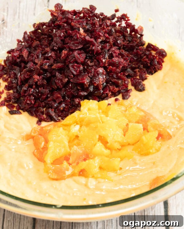 Sweet and Tart Cranberry Loaf 7 Dried cranberries and fresh orange segments being gently folded into the bread batter with a spatula.
