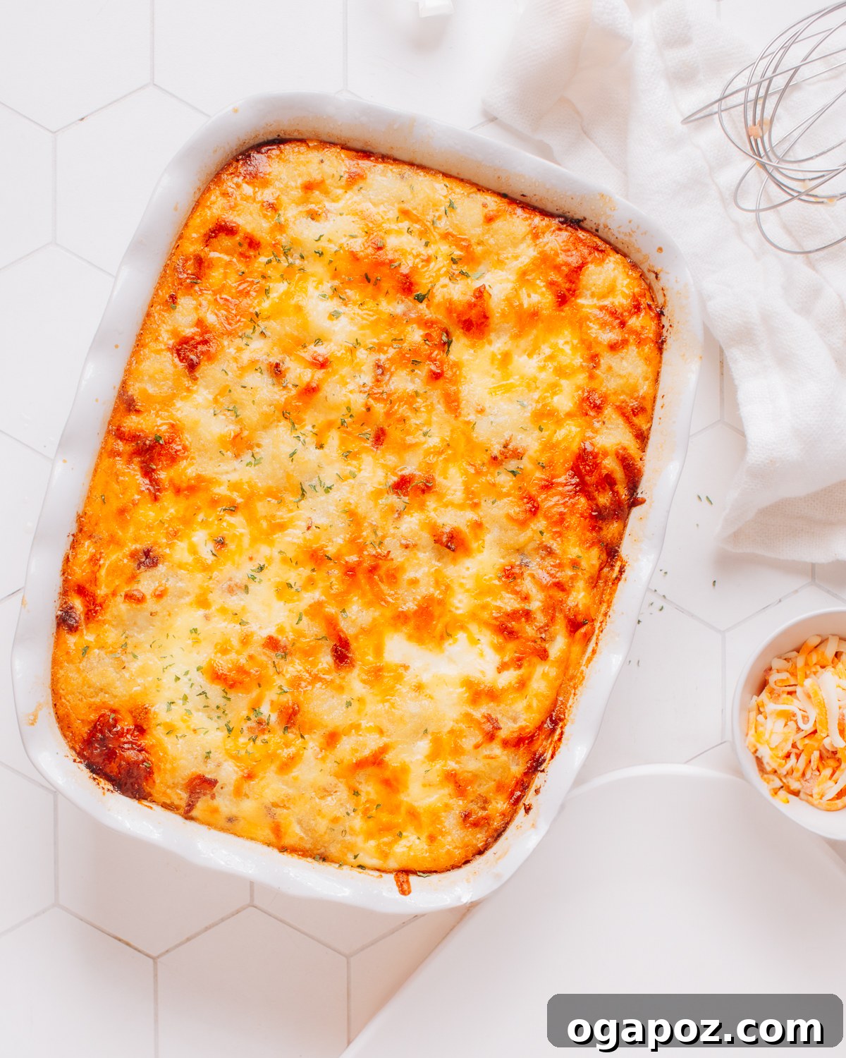 Effortless Comfort Chicken Potato Bake 6 A perfectly baked chicken potato casserole, garnished with fresh herbs, in a ceramic baking dish on a wooden surface.