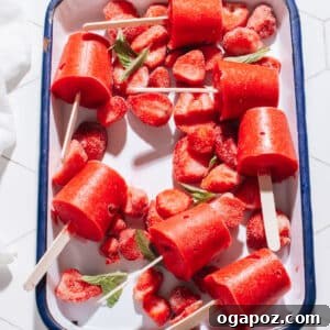 Delicious homemade strawberry popsicles on a wooden tray, ready to be served.