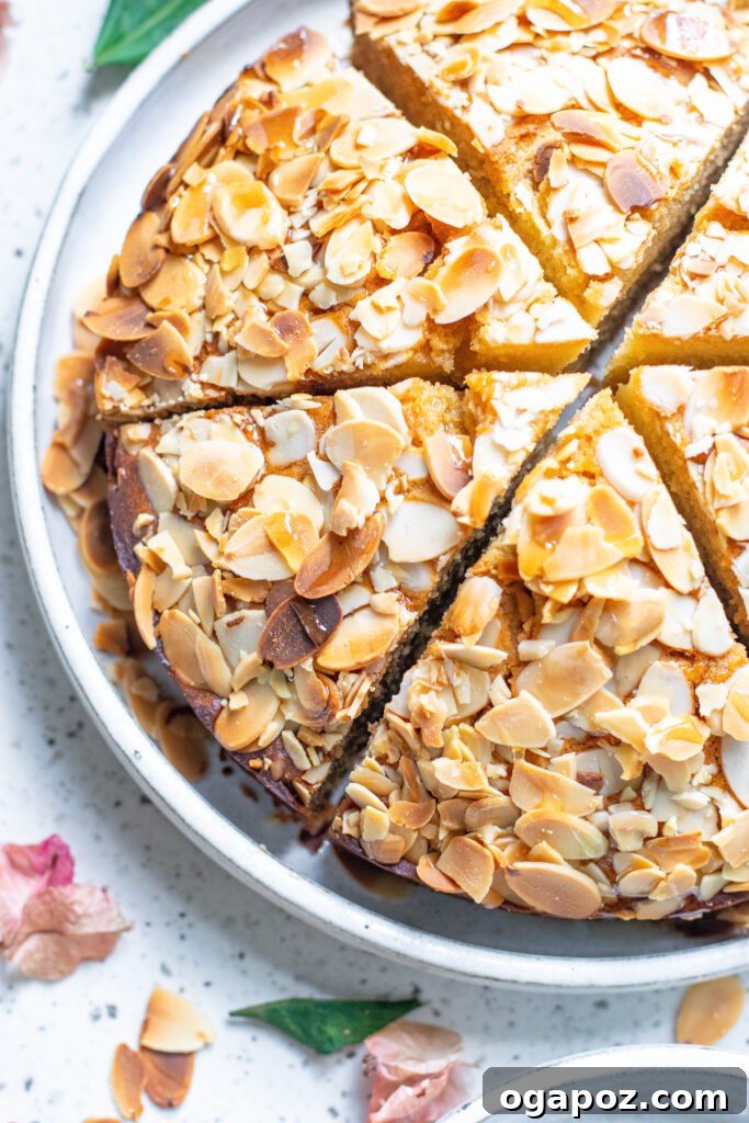 Heavenly Almond Cake 2 A slice of moist Honey Almond Cake on a plate, garnished with more almonds.