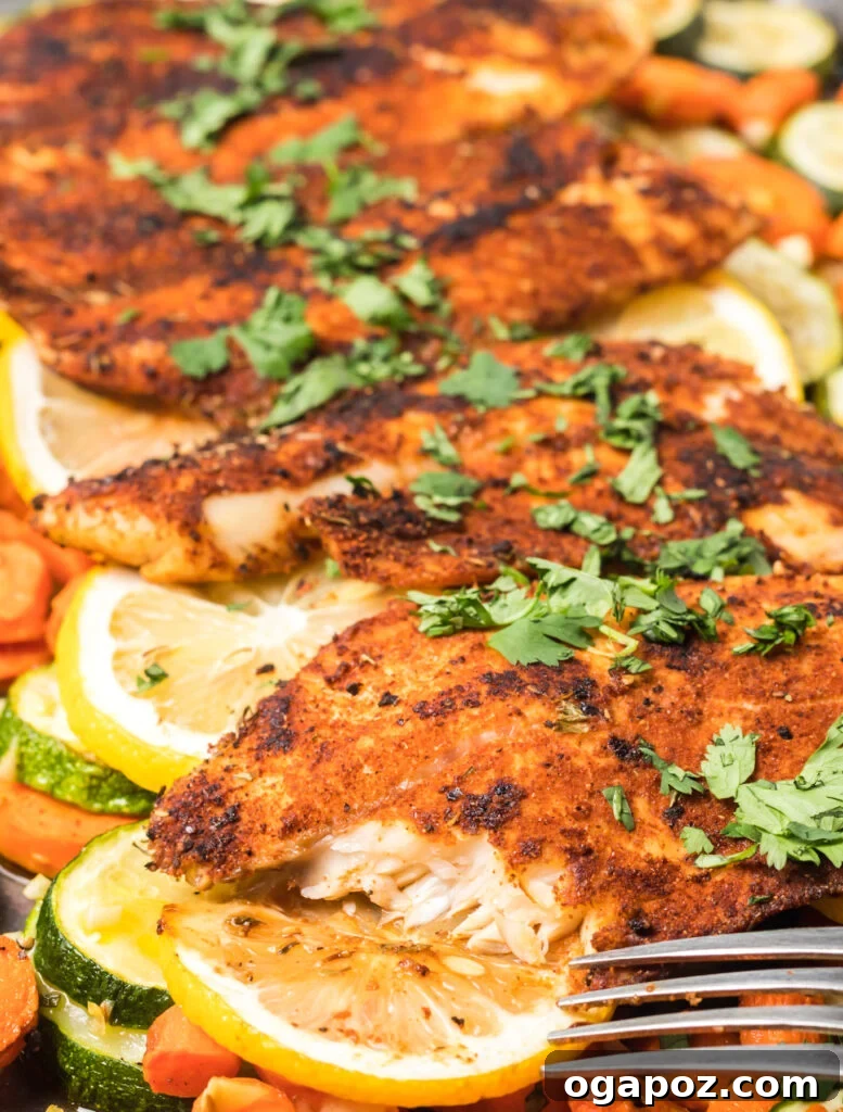 Effortless Blackened Tilapia 3 A fork taking a piece of Easy Blackened Tilapia Fish from a plate