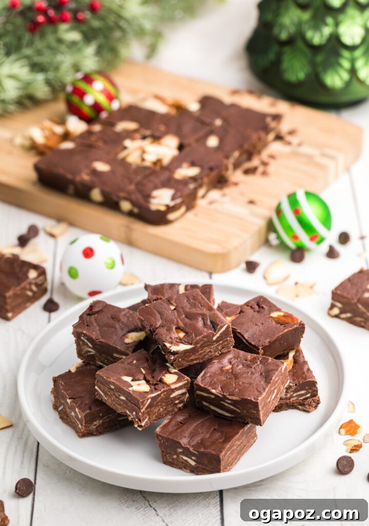 Effortless Chocolate Fudge 2 Easy Chocolate Fudge on a white plate, cut into squares, garnished with slivered almonds