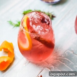 Cranberry Wine Spritzer in a glass with holiday garnishes