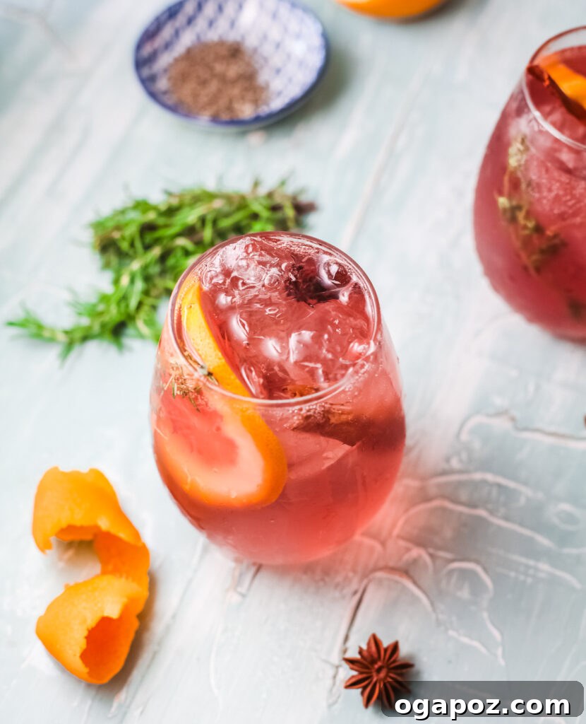 A close-up shot of Cranberry Wine Spritzer garnished with fresh orange slices and cranberries