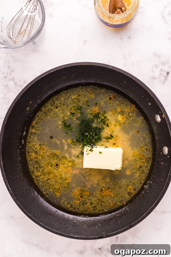 Golden Garlic Butter Seared Cod 9 The rich garlic butter sauce bubbling in the skillet after the cod has been removed