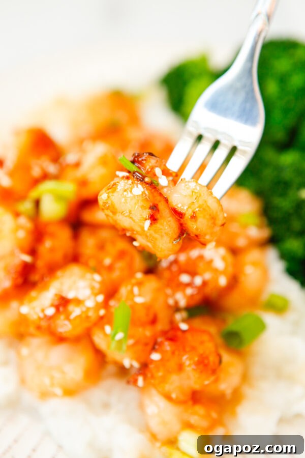 Sticky Sriracha Honey Garlic Shrimp 2 Irresistible Honey Garlic Sriracha Shrimp served with a fork, ready to be enjoyed