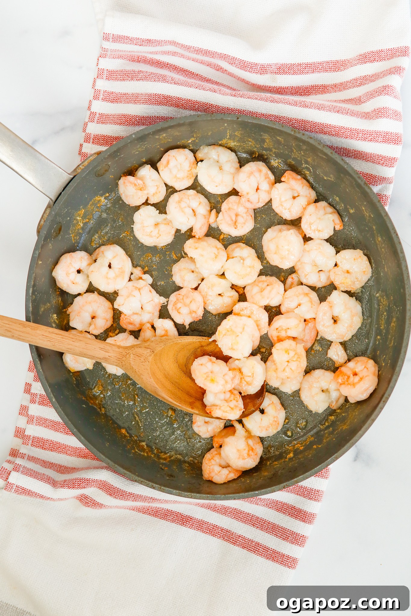Sticky Sriracha Honey Garlic Shrimp 5 Fresh shrimp cooking in a hot skillet, beginning to turn pink and opaque