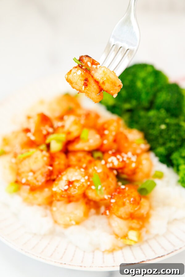 Sticky Sriracha Honey Garlic Shrimp 8 Close-up view of a perfectly glazed Honey Garlic Sriracha Shrimp on a fork