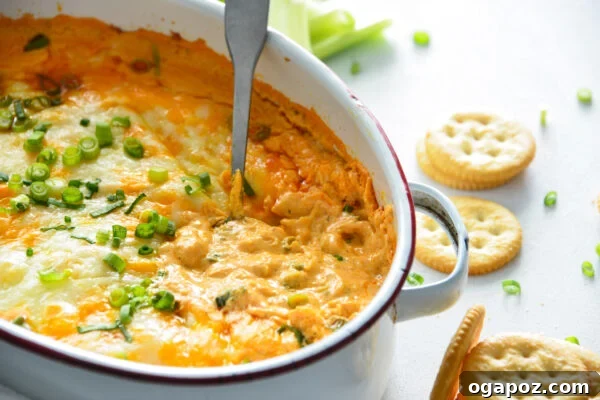 Ultimate Buffalo Chicken Dip Recipe 9 Baked Buffalo Chicken Dip in a white ceramic dish with a serving spoon