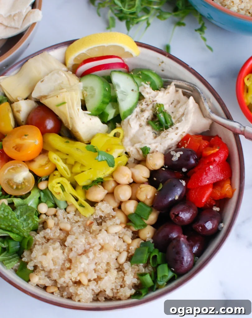 Zesty Greek Quinoa Nourish Bowl 5 Greek Quinoa Bowl garnished with a dollop of creamy hummus