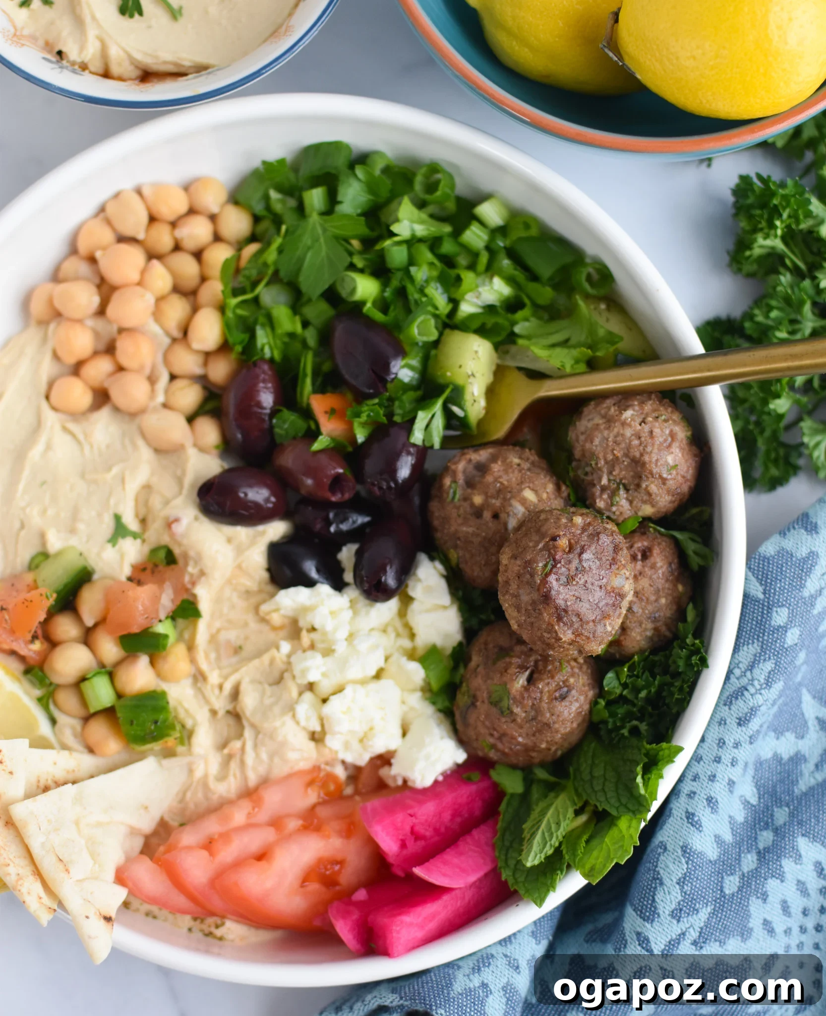 Spiced Lamb Kofta 2 Lamb Kofta in a vibrant hummus bowl with a fork, ready to be enjoyed.