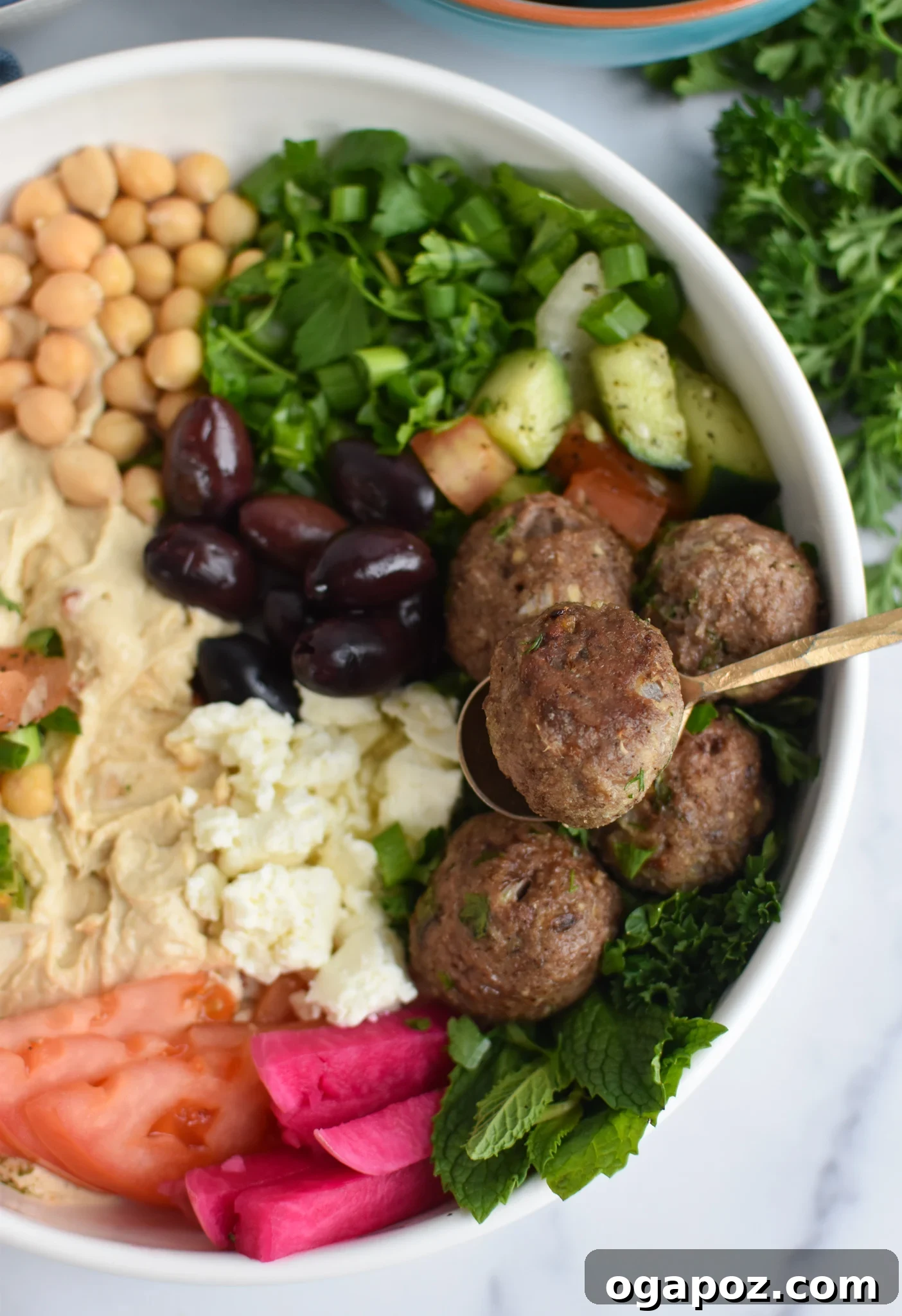 Spiced Lamb Kofta 8 Lamb Kofta in a hummus bowl with a fork.