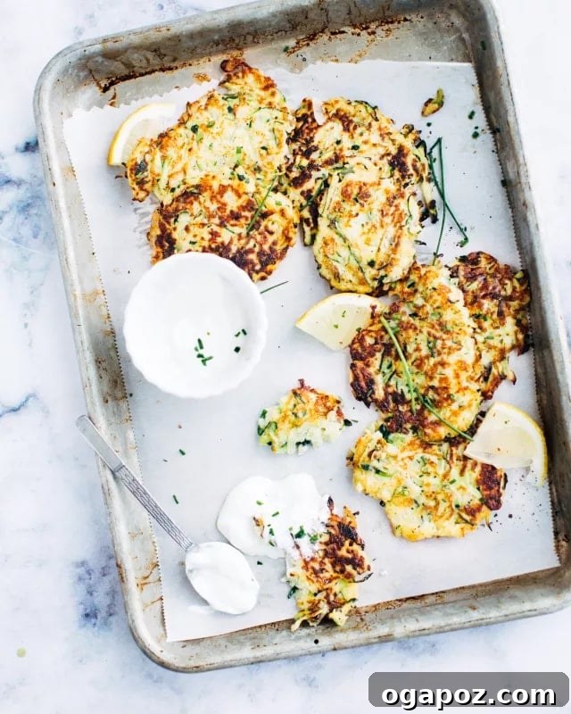 Crispy Zucchini Bites 2 Delicious Zucchini Fritters piled high on a plate, ready to be enjoyed.