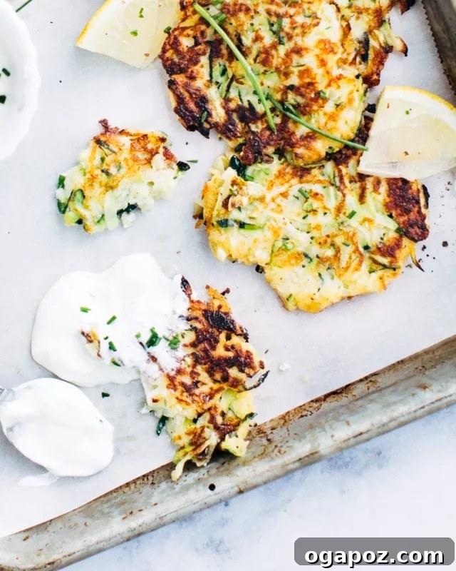 Crispy Zucchini Bites 4 A plate of golden-brown zucchini fritters served with a side of creamy dip.