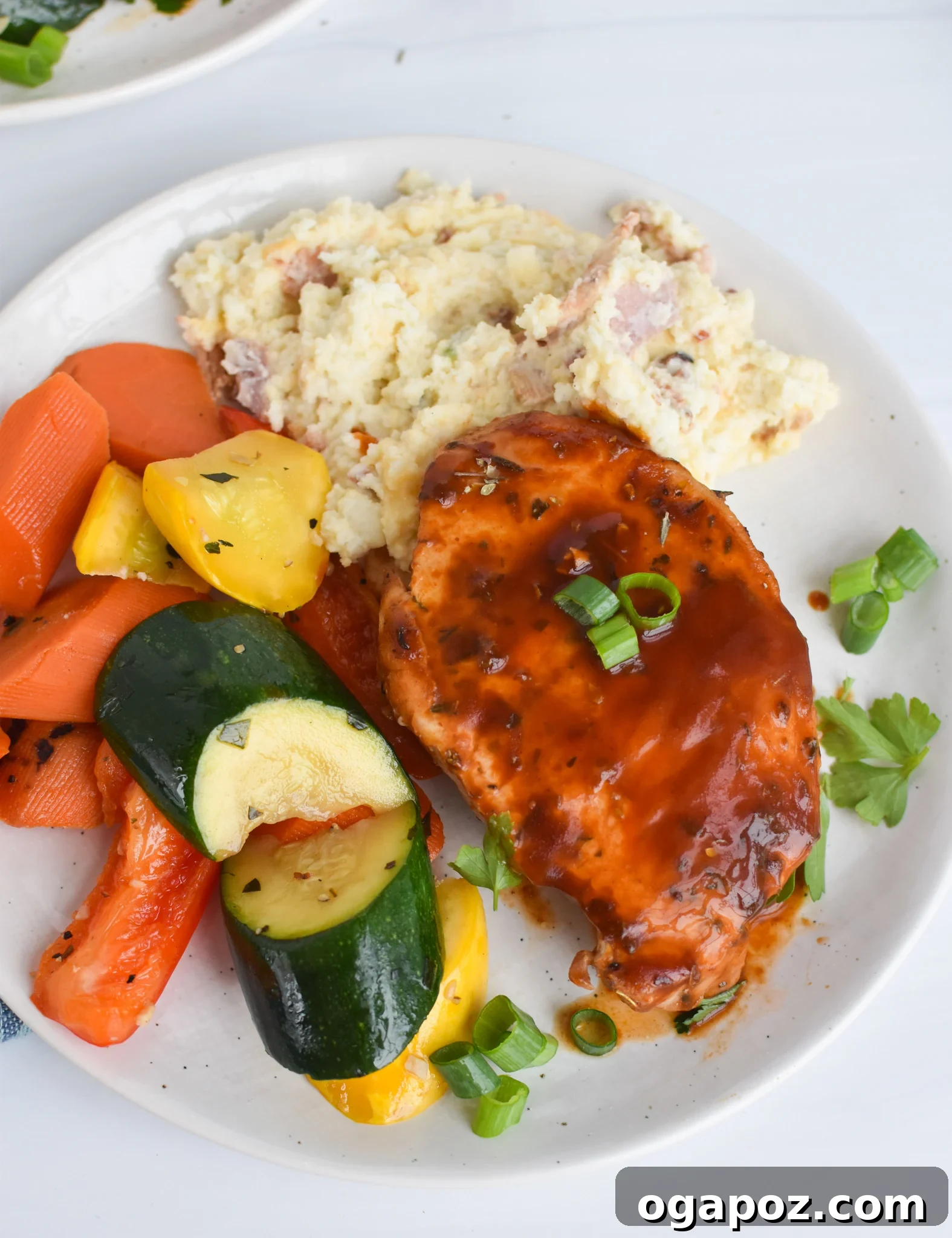 Succulent Oven Baked BBQ Pork Chops 9 Plated BBQ Baked Pork Chops served with mashed potatoes and green beans, ready to eat.