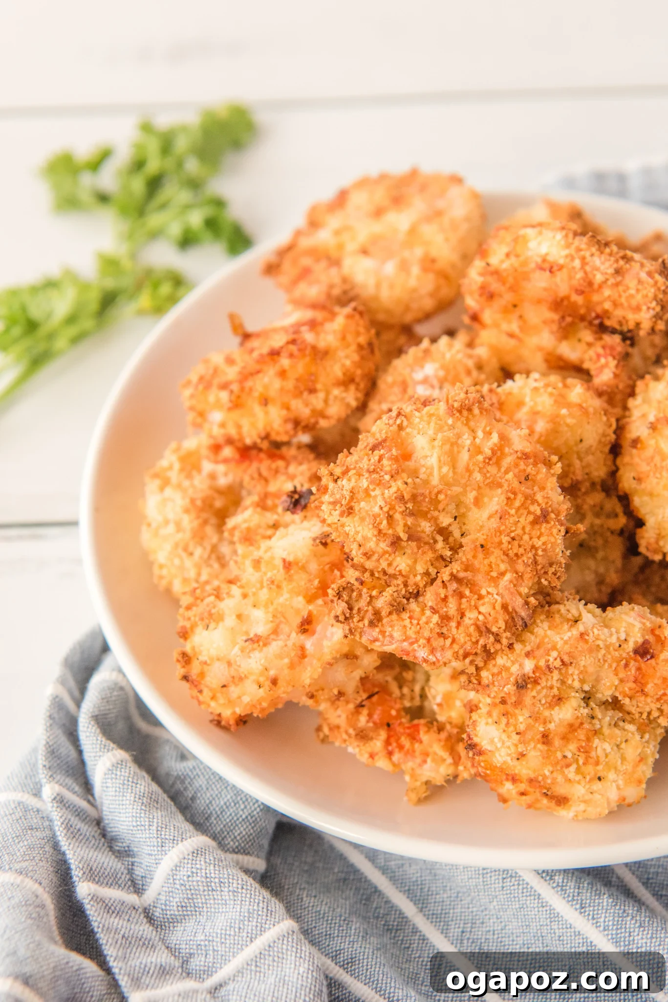 Crispy Air-Fried Coconut Shrimp 4 Air Fryer Coconut Shrimp on a plate on a napkin.