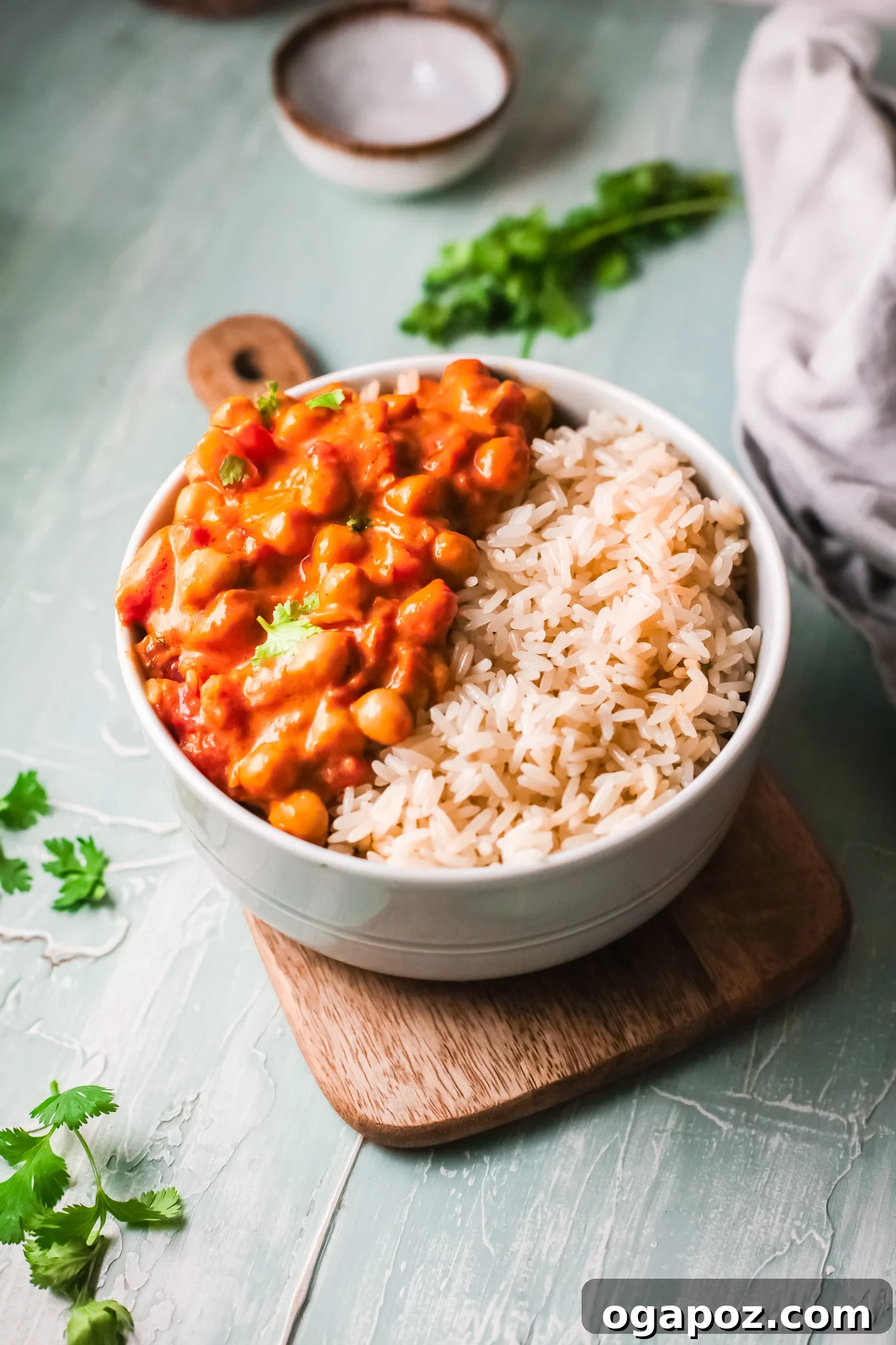 Golden Chickpea Curry 2 A bowl of creamy Chickpeas with Curry, garnished with fresh cilantro, served alongside fluffy white rice.