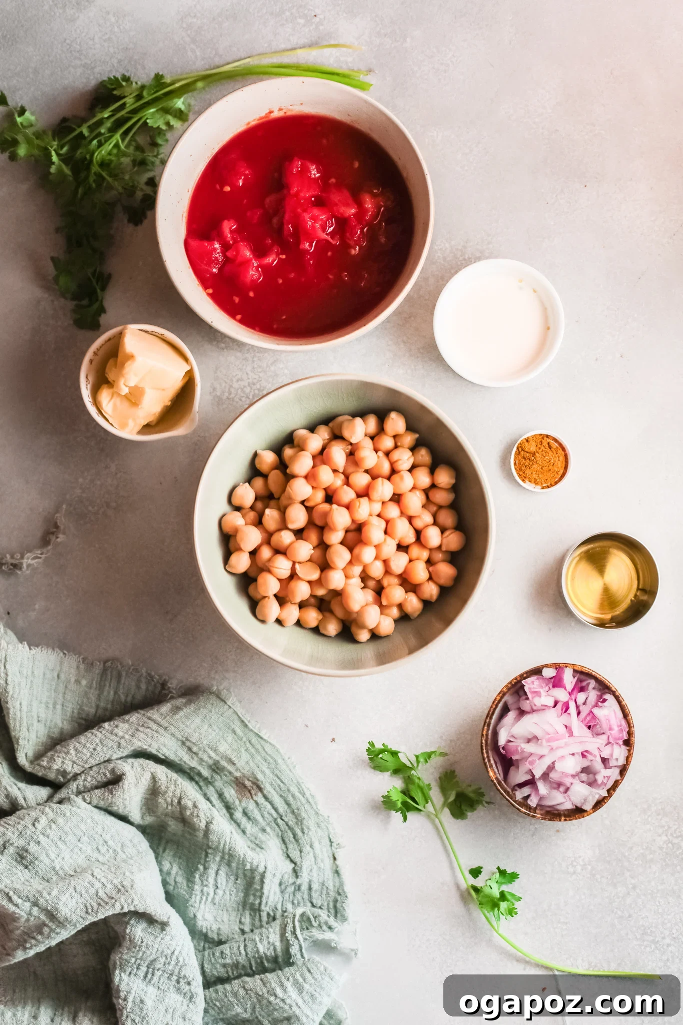 Golden Chickpea Curry 3 Individual ingredients laid out for Chickpeas with Curry, including canned tomatoes, chickpeas, curry powder, onions, and garlic.