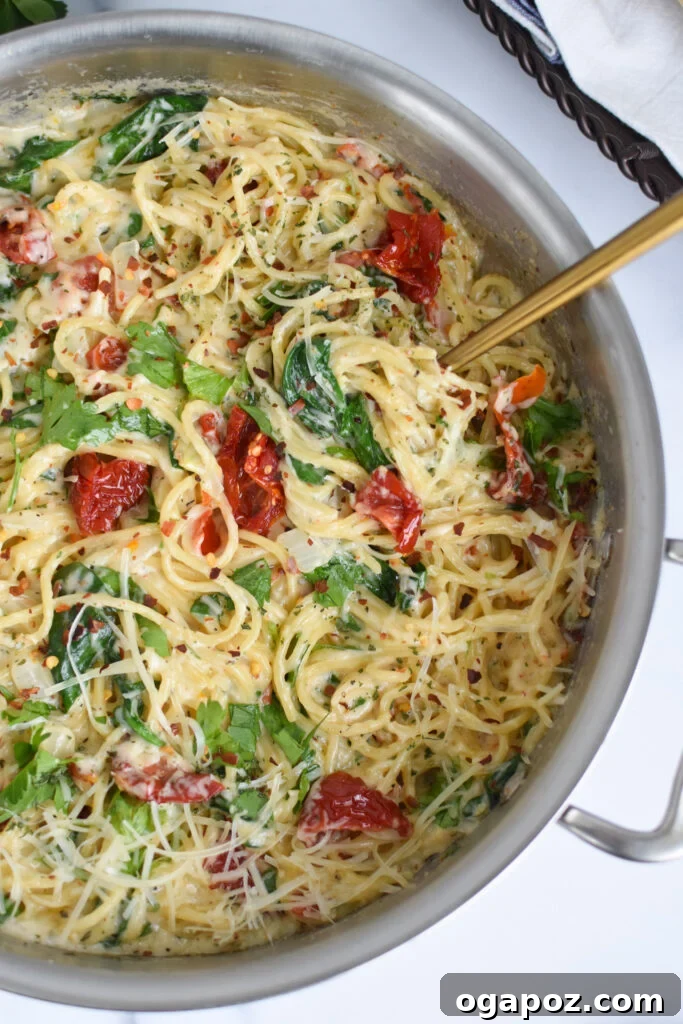 Luscious Creamy Sundried Tomato Pasta 5 Creamy Sun Dried Tomato Pasta Recipe with spoon lifting some pasta from the pan.