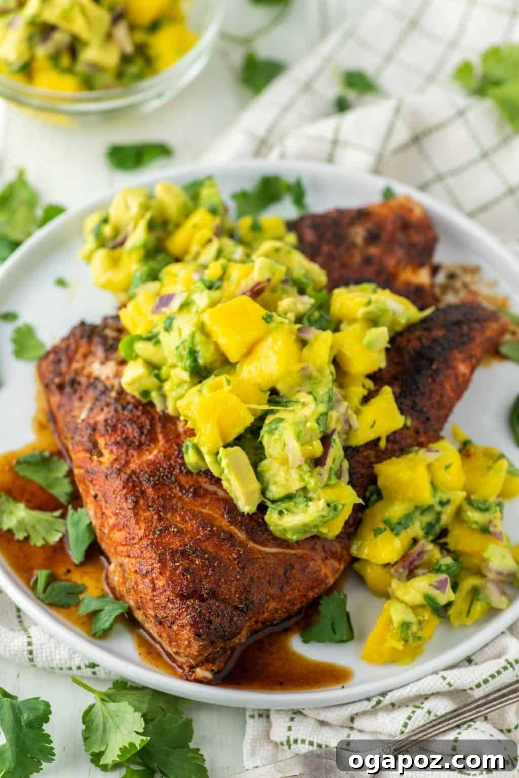 Halibut Perfection: Recipes You'll Adore 13 Blackened halibut topped with a creamy avocado and mango salsa, a vibrant and flavorful dish.