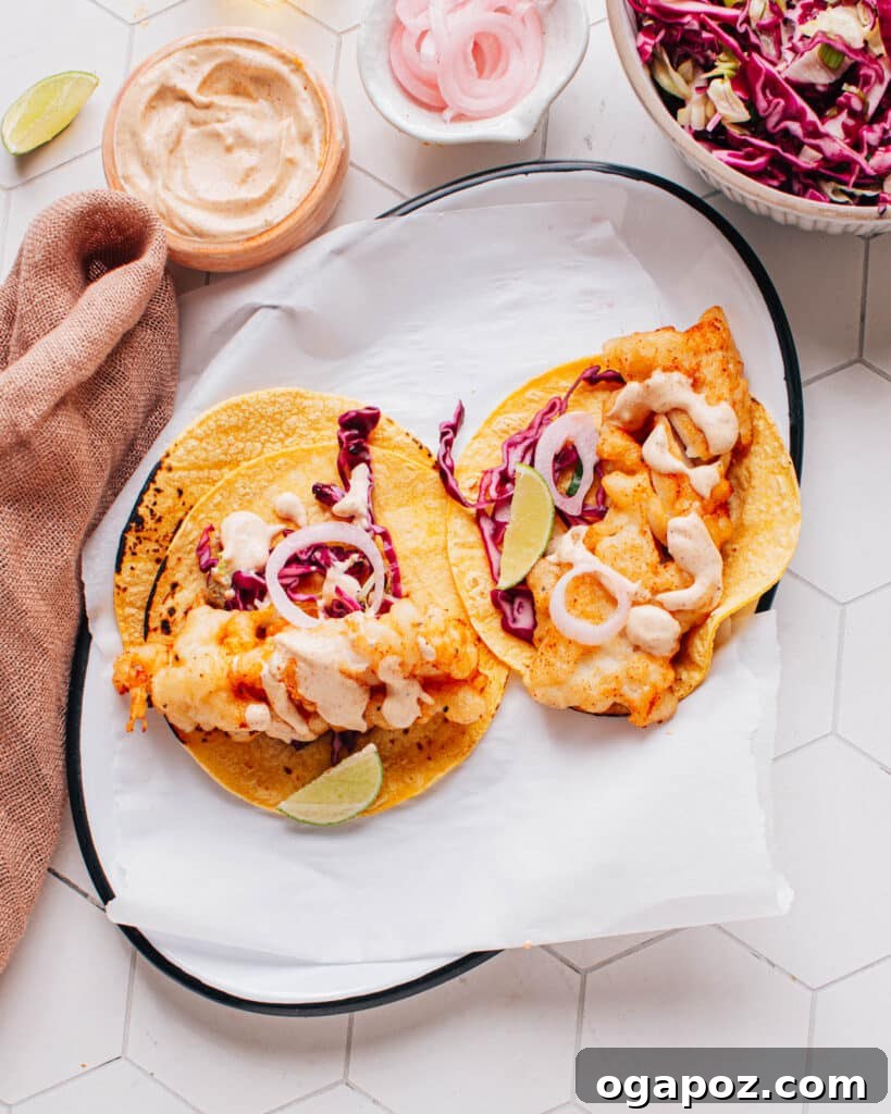 Halibut Perfection: Recipes You'll Adore 4 Crispy beer-battered Baja fish tacos served on a platter with creamy sauce and crunchy slaw.