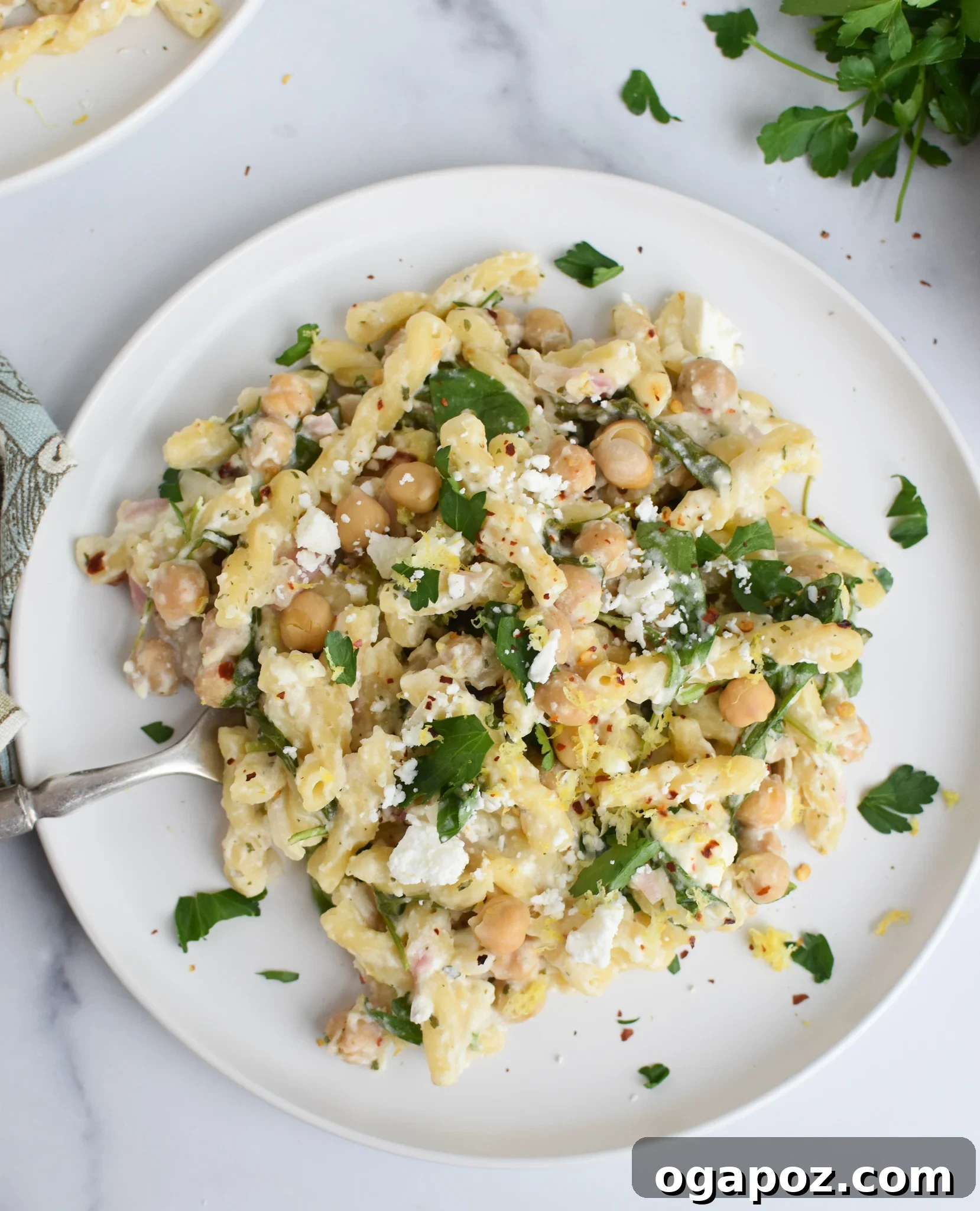 Mediterranean Chickpea Feta Pasta 5 Close-up of Chickpea Pasta Recipe with Feta on a white plate with parsley garnish.