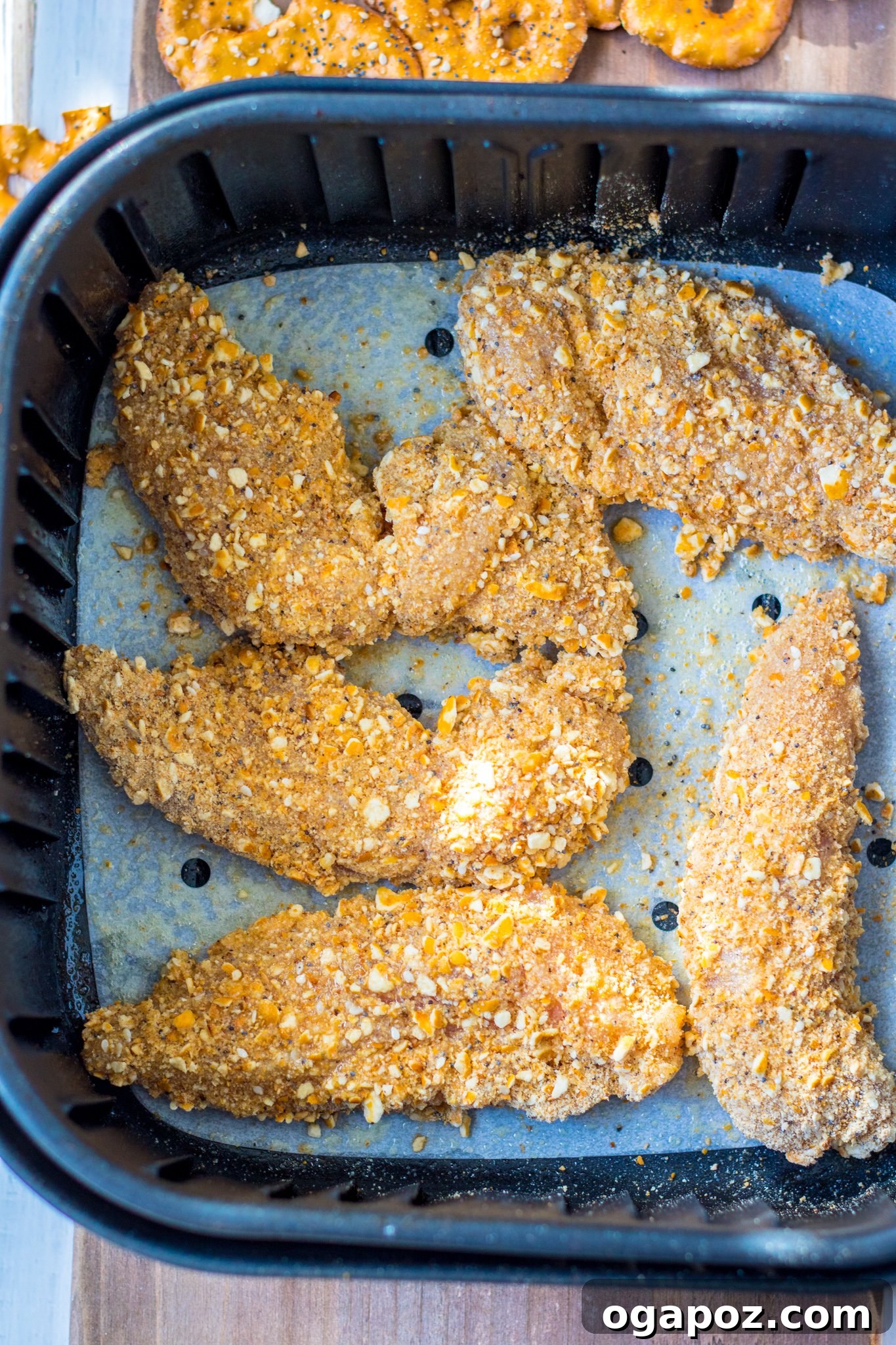 Crispy Pretzel Chicken Dinner 6 Freshly air-fried Pretzel Crusted Chicken tenders in an air fryer basket, showing their crispy texture.