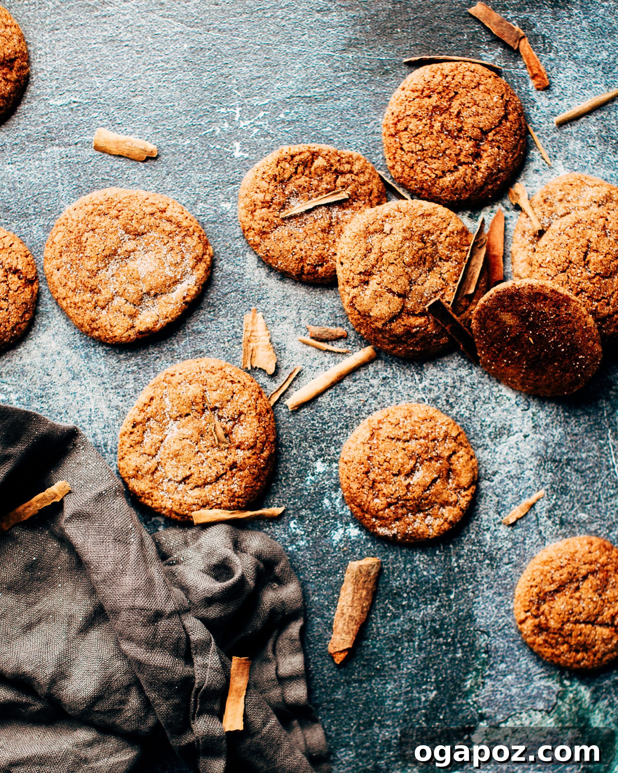 Sweet and Spicy Apple Cinnamon Gingersnaps 3 A stack of soft and chewy apple-cinnamon gingersnap cookies on a plate, with a hint of apples in the background.