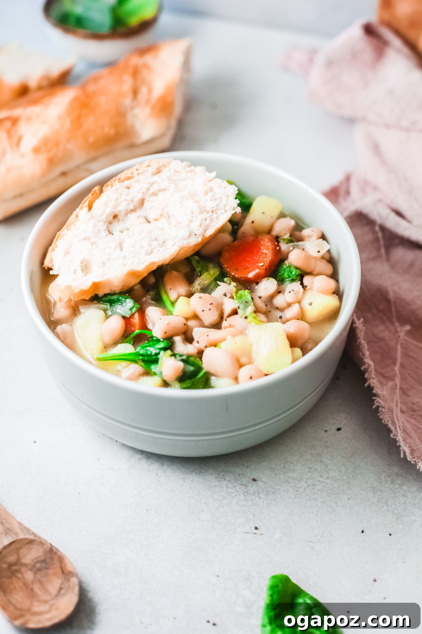 A steaming bowl of Instant Pot Bean Soup, generously garnished with fresh parsley and grated Parmesan cheese, with a side of crusty bread.