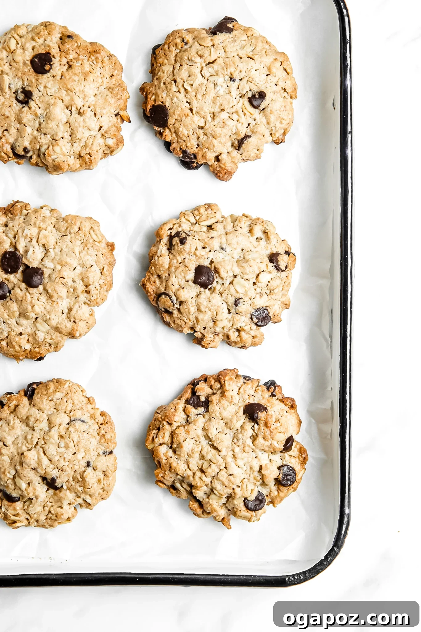 Soft-Baked Banana Oatmeal Cookies 4 A baking tray filled with golden brown Homemade Banana Oatmeal Cookies, cooling after being removed from the oven.