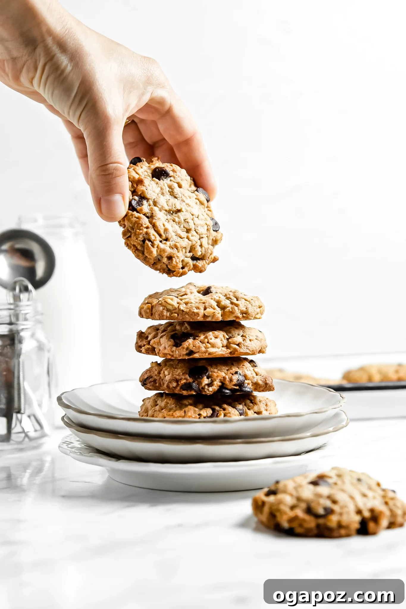Soft-Baked Banana Oatmeal Cookies 9 A stack of golden brown Homemade Banana Oatmeal Cookies, showing their soft, chewy texture with visible oats and chocolate chips.
